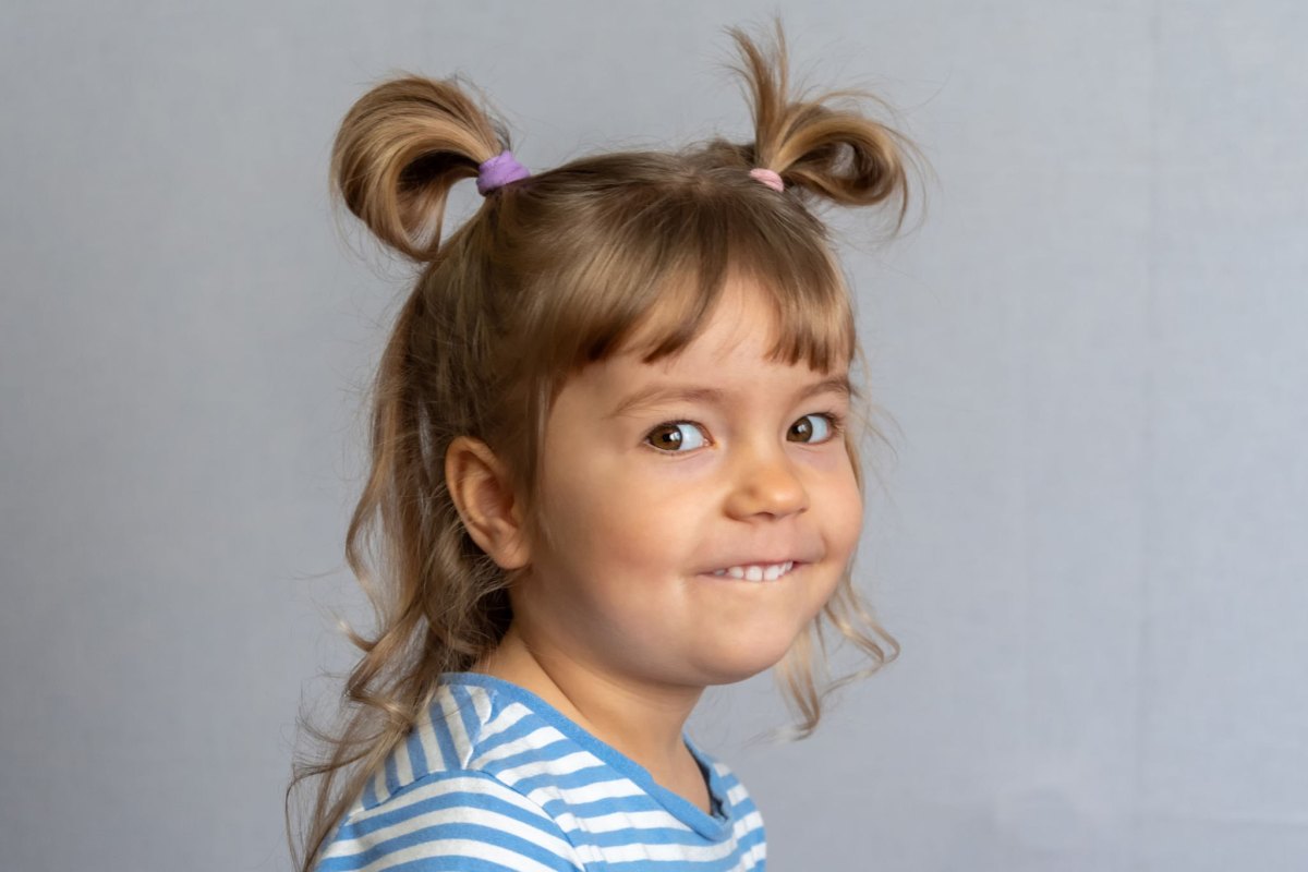 Playful toddler girl smiling with two high pigtails
