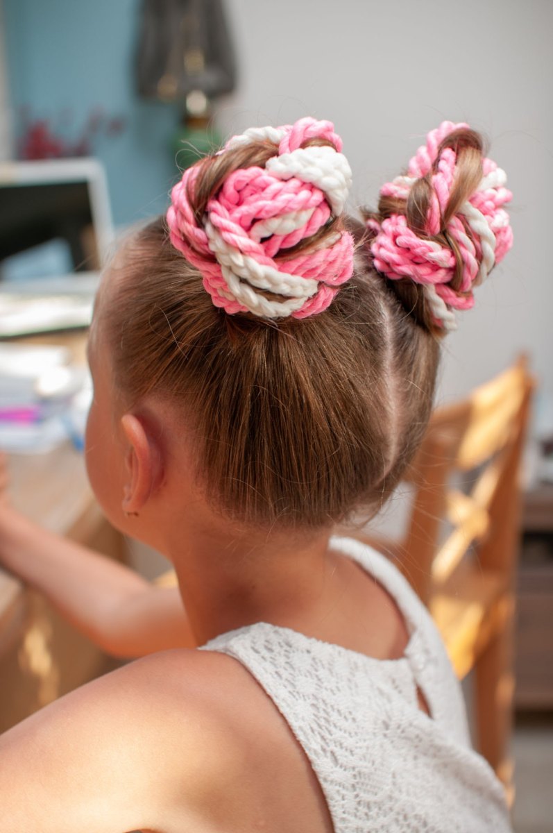 Back view of a toddler girl with colorful criss-cross elastics and pigtails