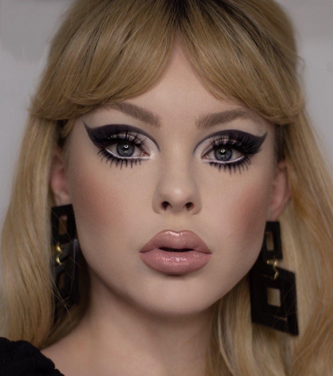 Applying graphic eyeliner with dramatic 60s lashes