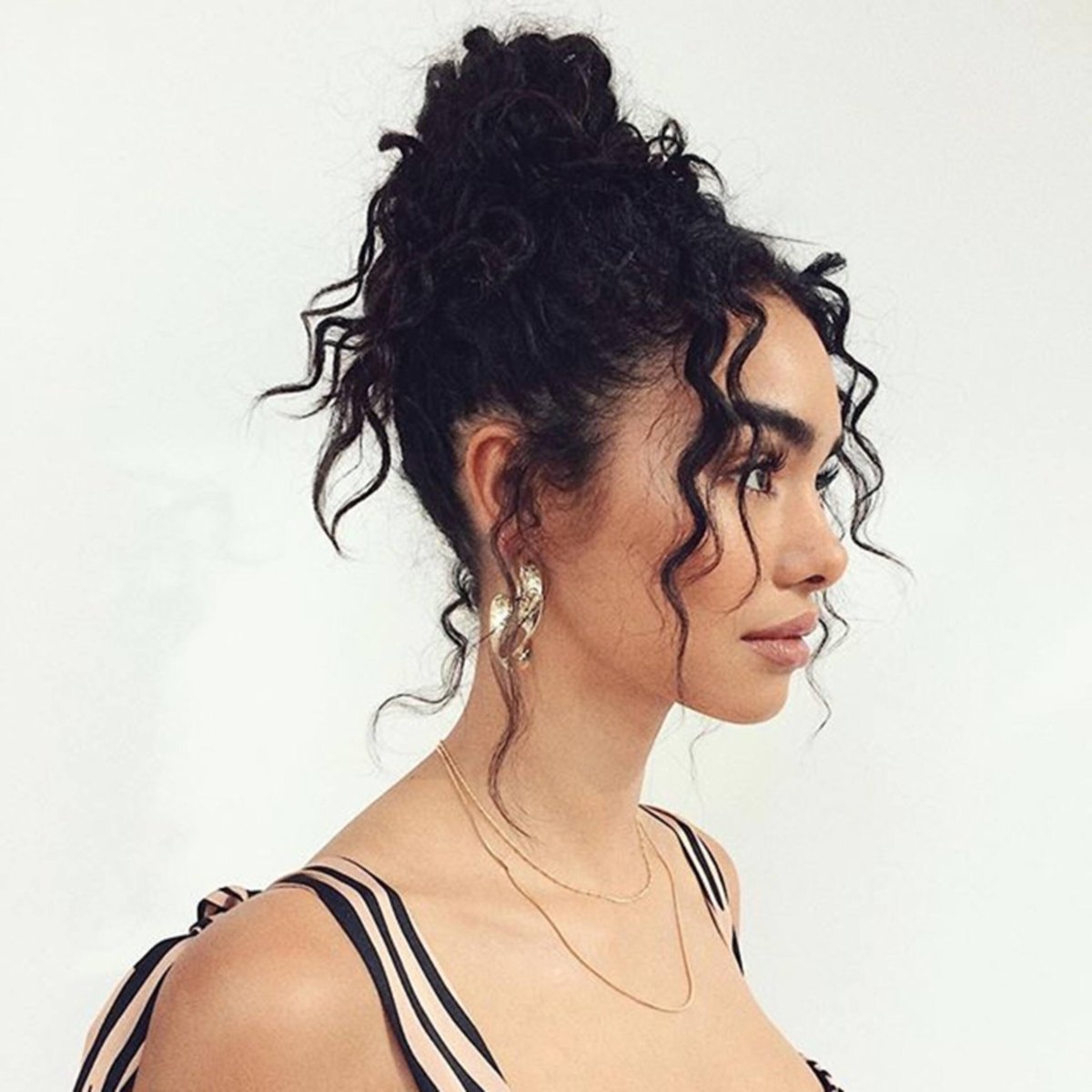 Messy curly bun hairstyle with loose curls