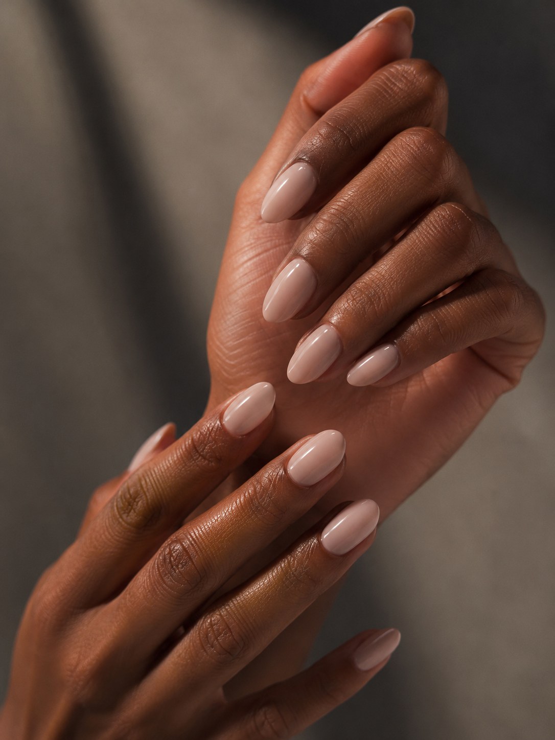 Warm sheer nude pink nails on deep skin tones, showing how undertone changes the finish