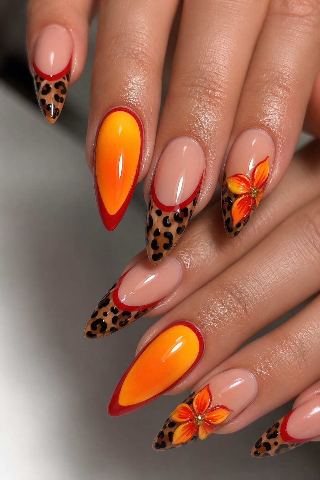 Almond stiletto neon nails for dark skin with orange ombré, red outline and leopard print detailing