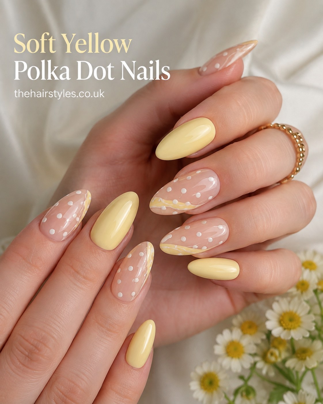 Soft yellow almond nails with hand-painted white polka dots over a sheer pastel base