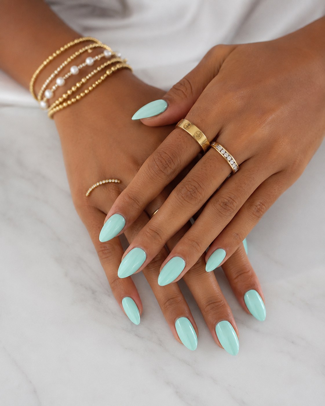 Mint green almond nails, a warm pastel nail color that suits dark skin