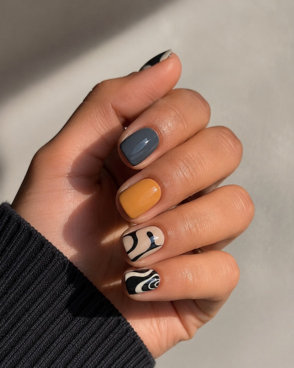 Mismatched grey, mustard and swirl nails, a creative summer nail color for dark skin