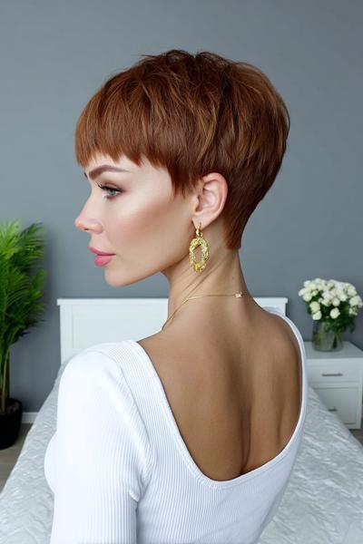 A woman with a copper-coloured undercut pixie hairstyle, featuring short, neatly tapered sides and back with longer, textured layers on top.